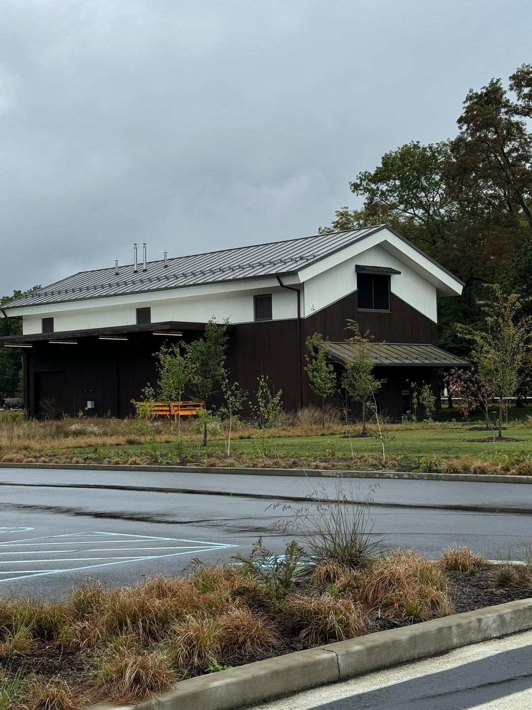 The Dassai Blue Sake Brewery in Hyde Park: a dark timber-clad building with a white gable and metal roof, seen from the car park