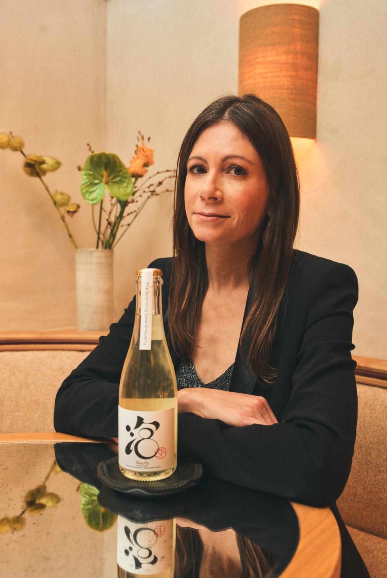 Tracey Delaney holding a bottle of AWA sparkling sake