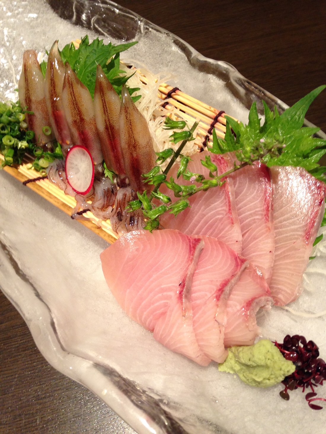 Kan-buri, fatty winter yellowtail, served as sashimi on ice with firefly squid and shiso