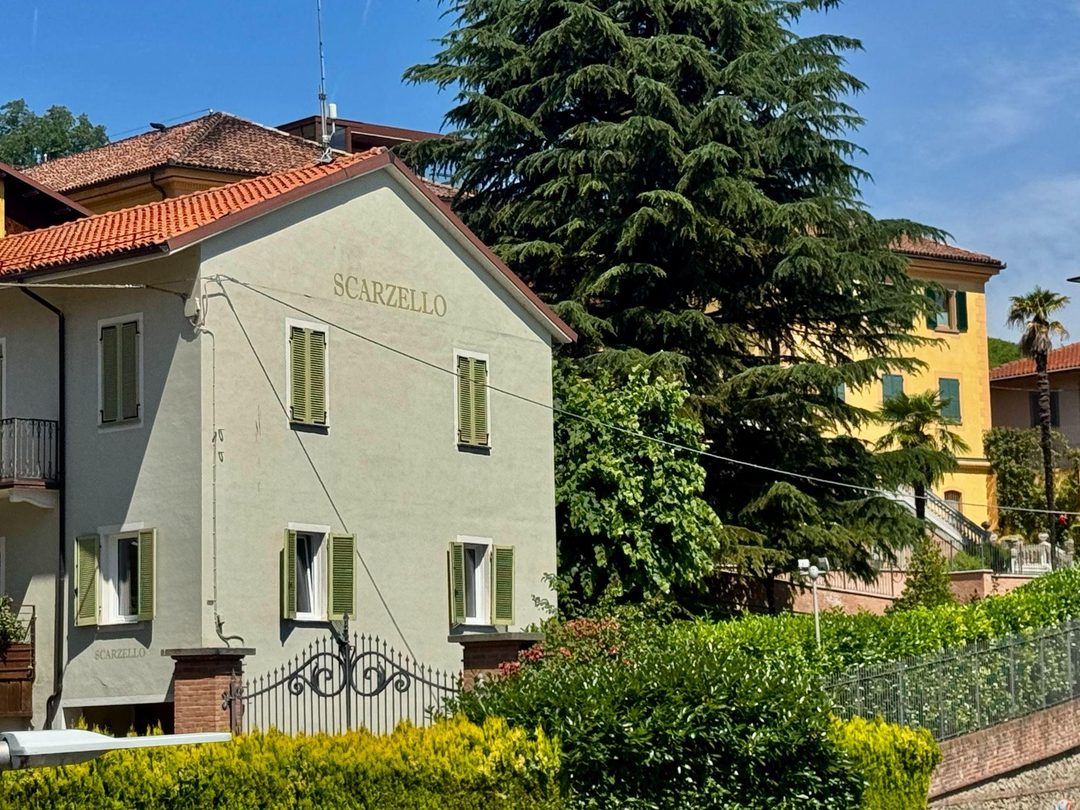 The Scarzello winery building with the family name painted on its gable, green shutters and a cedar tree alongside